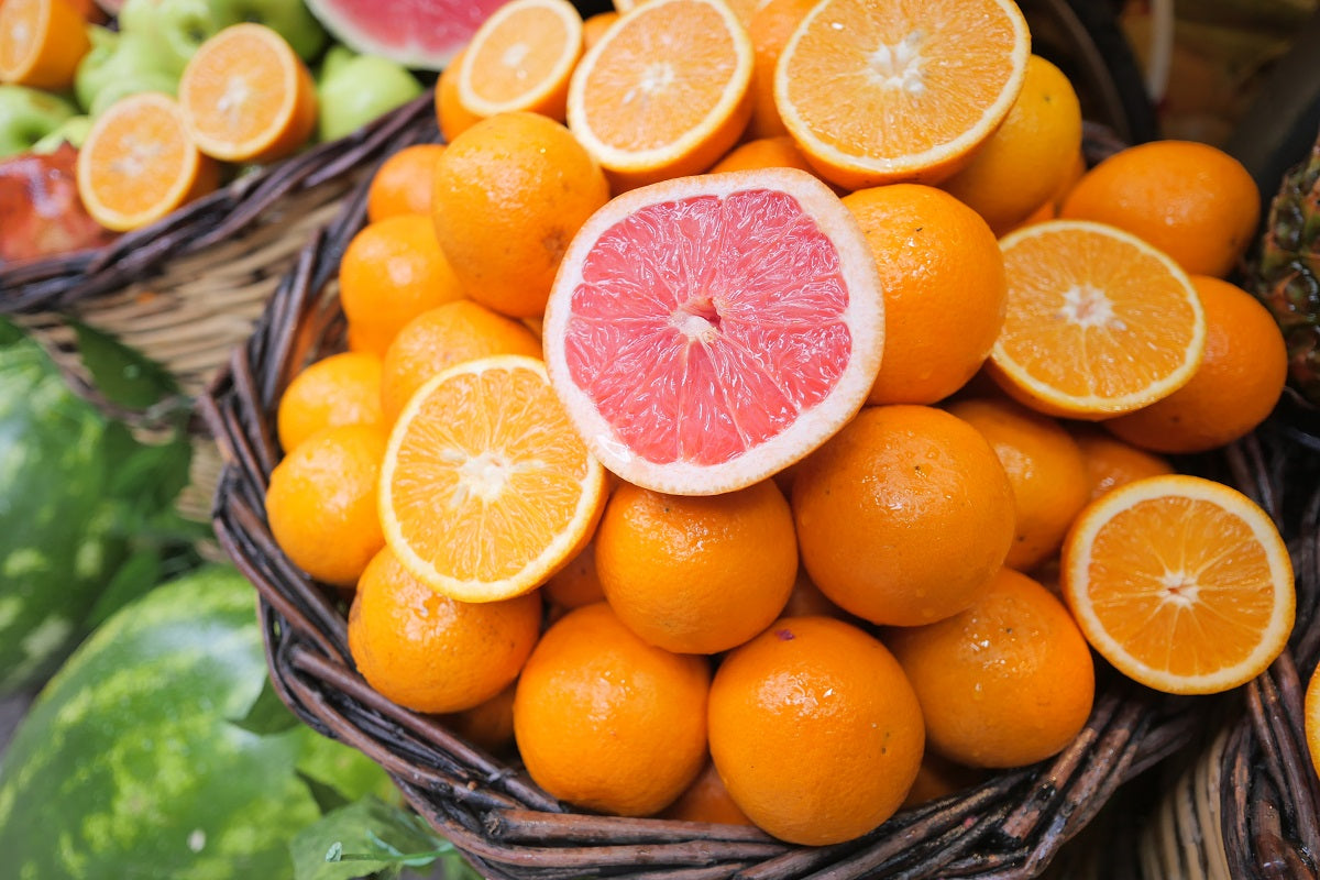 A basket of oranges and grapefruit on display