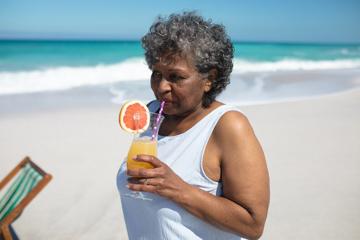 An elderly woman drinking grapefruit juice