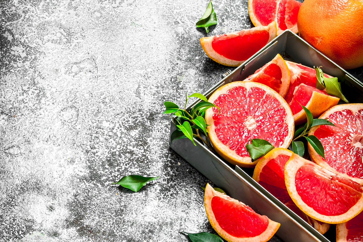 Fresh red grapefruit on a tray with sugar sprinkled on the board
