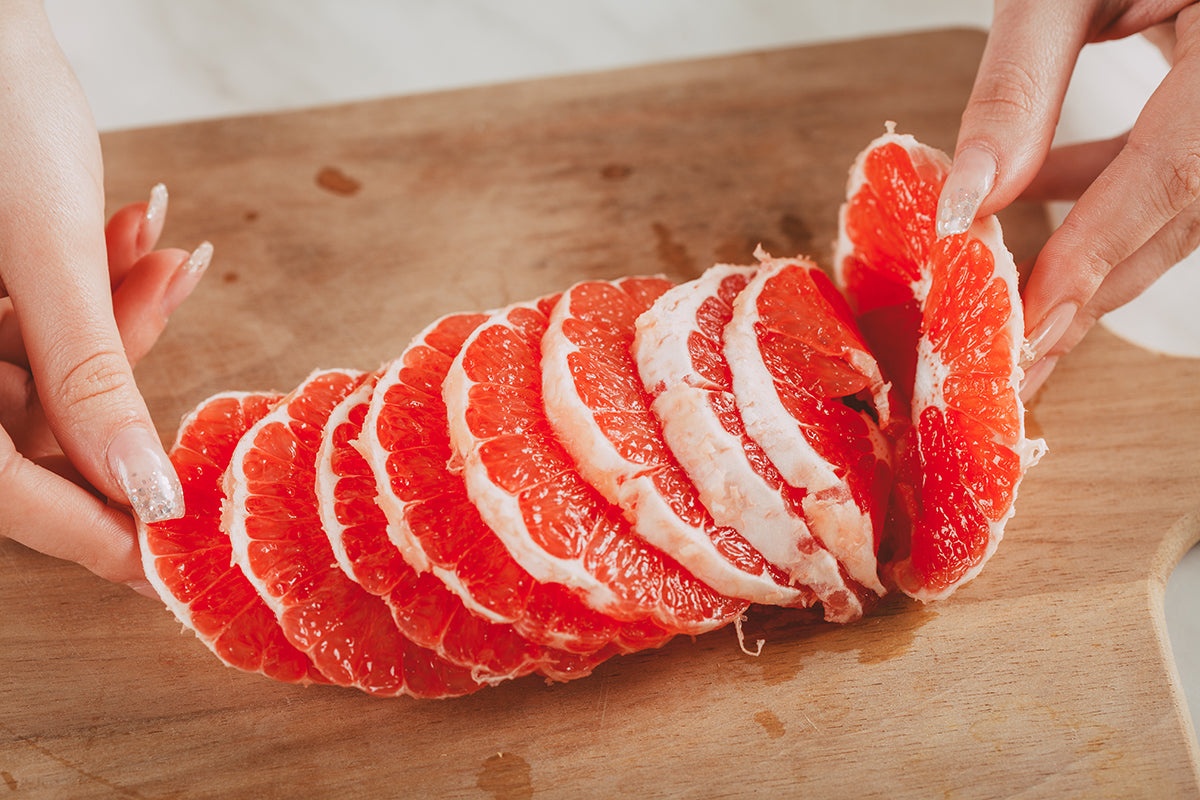 Multiple slices of red grapefruit on a table