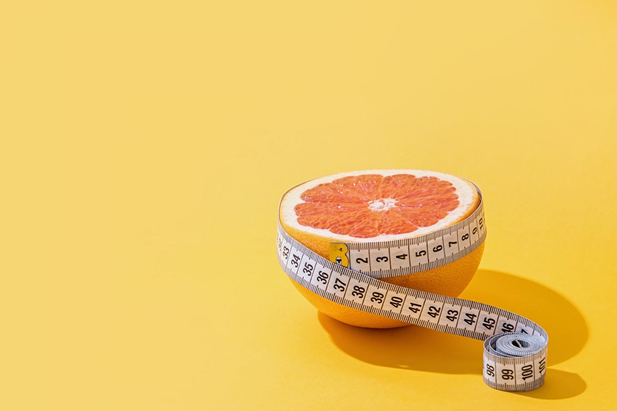 A grapefruit wrapped in a measuring tape