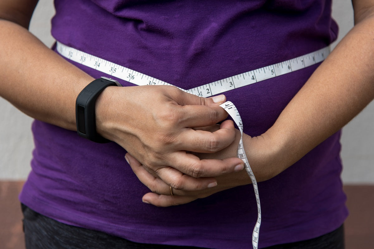 A person measuring their waist