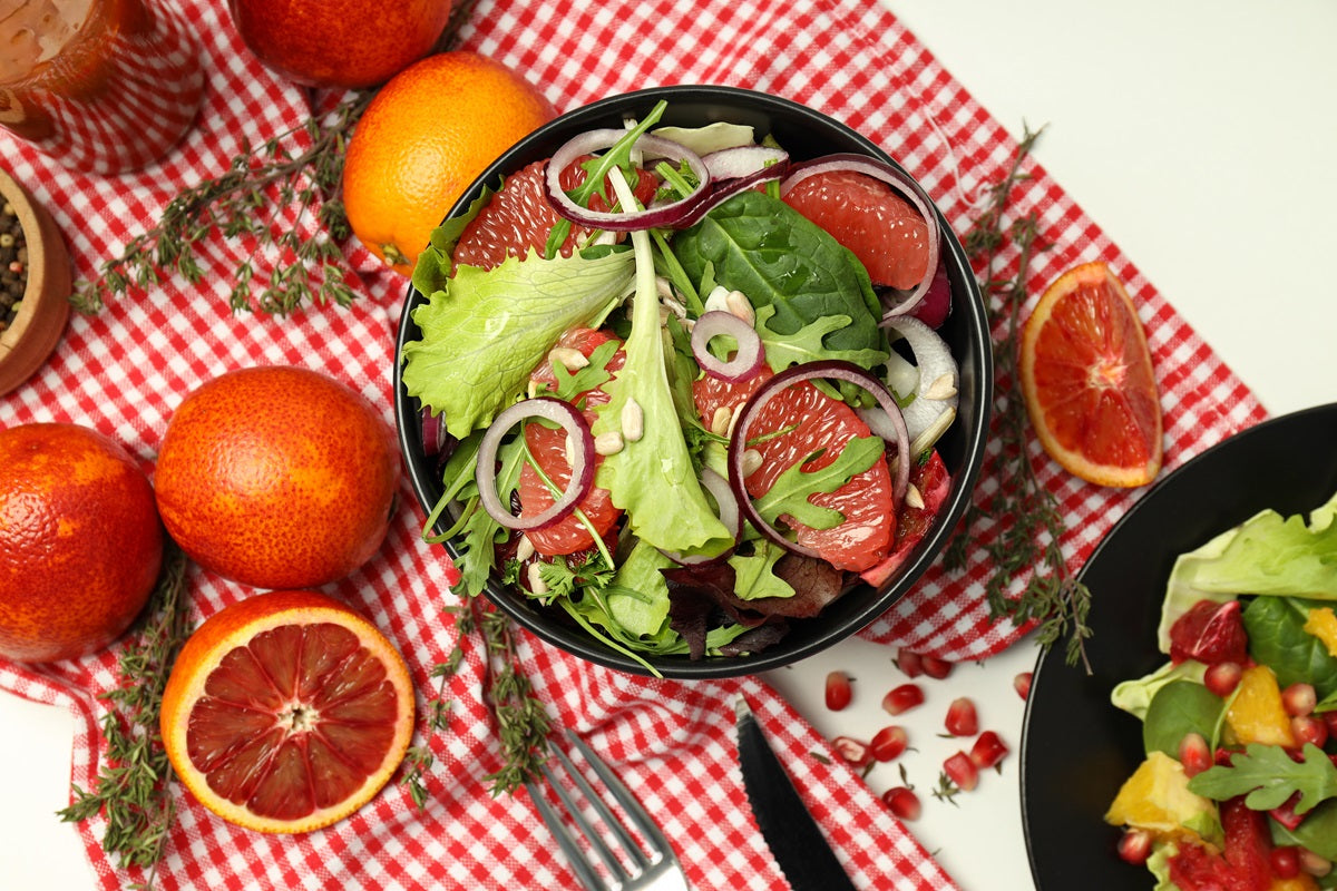 A grapefruit salad surrounded by ingredients