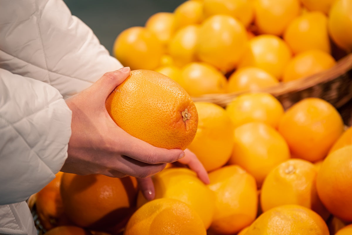 A woman buying grapefruit