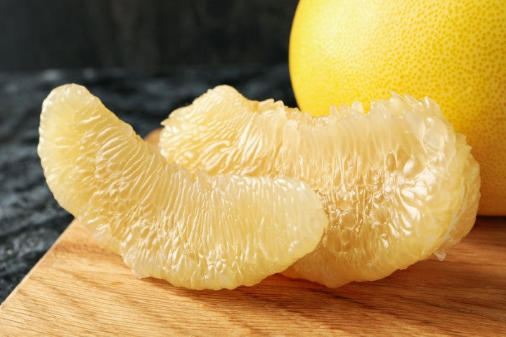 White grapefruit slices next to a whole white grapefruit