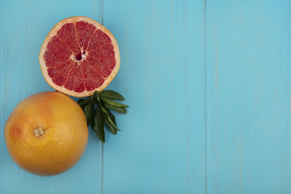 Whole grapefruit and half a grapefruit on a table